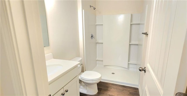 bathroom featuring vanity, hardwood / wood-style flooring, toilet, and walk in shower