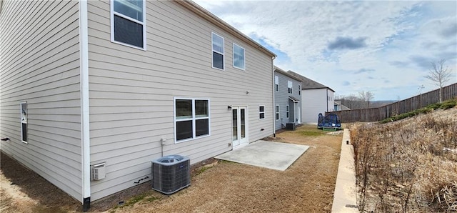 view of side of home with a trampoline, central AC unit, and a patio area