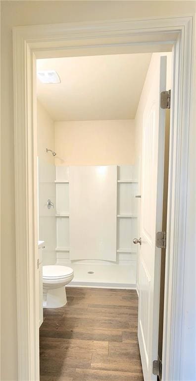 bathroom featuring a shower, toilet, vanity, and hardwood / wood-style flooring