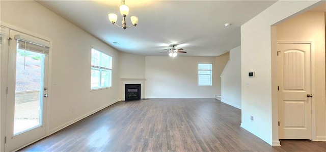 unfurnished living room with dark hardwood / wood-style floors and ceiling fan with notable chandelier