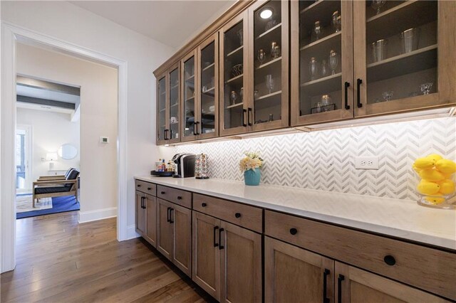 dining space with crown molding, a tray ceiling, dark wood-type flooring, and a chandelier