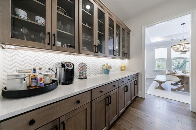 bar featuring tasteful backsplash and dark wood-type flooring