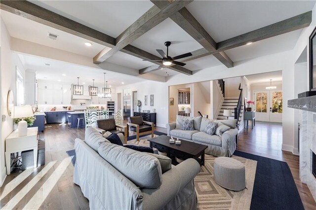 unfurnished living room featuring beam ceiling, a high end fireplace, and dark wood-type flooring