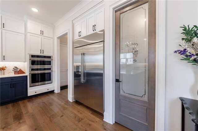 kitchen featuring premium range hood, pendant lighting, and white cabinets