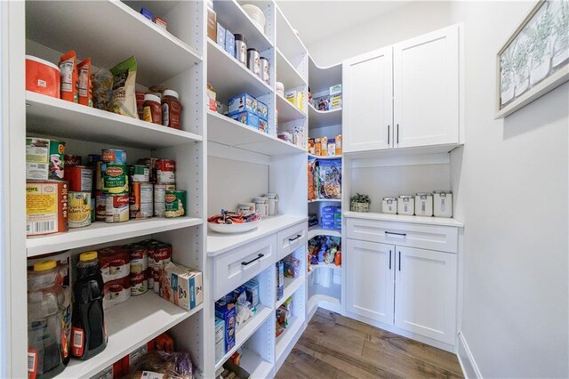 kitchen with appliances with stainless steel finishes, dark wood-type flooring, white cabinets, and backsplash