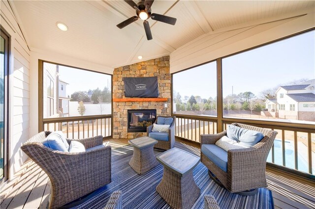 interior space with lofted ceiling with beams, ceiling fan, and a fireplace