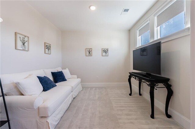 bedroom featuring multiple windows, light colored carpet, and ceiling fan