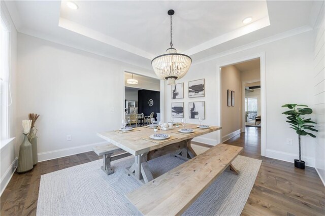 dining room featuring dark hardwood / wood-style floors, an inviting chandelier, and a tray ceiling