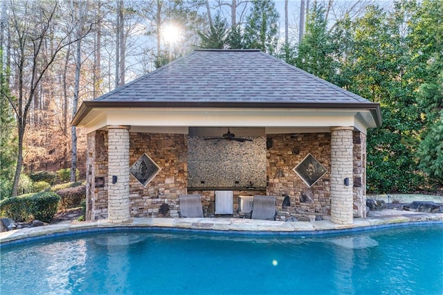 pool featuring a patio area, a fireplace, and a ceiling fan