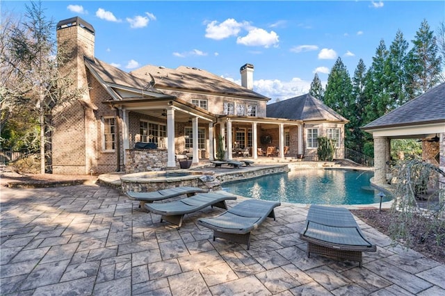 pool featuring ceiling fan, a patio area, and a hot tub