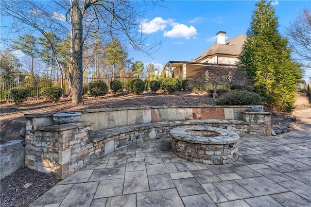 view of patio with a fire pit and fence