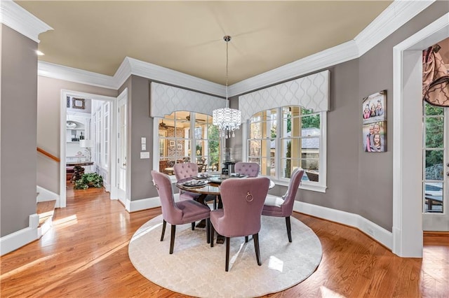 dining area with light wood finished floors, baseboards, and crown molding