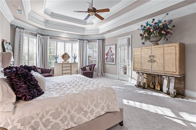 bedroom with a tray ceiling, access to outside, visible vents, and multiple windows