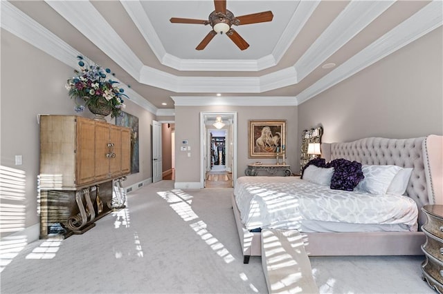 bedroom featuring baseboards, light colored carpet, ceiling fan, a tray ceiling, and crown molding