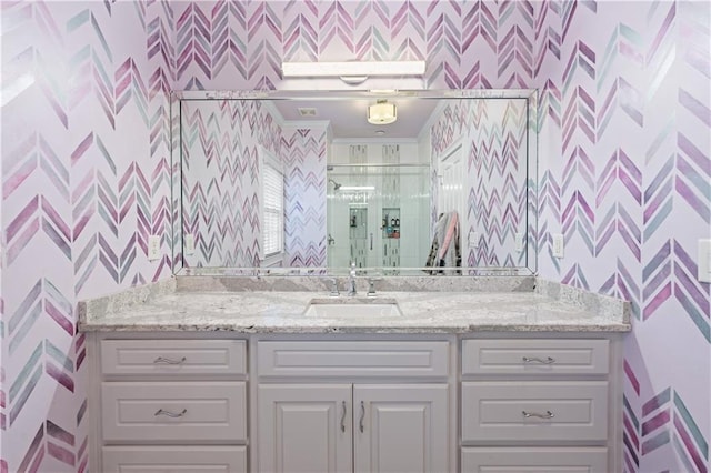 bathroom featuring vanity and wallpapered walls