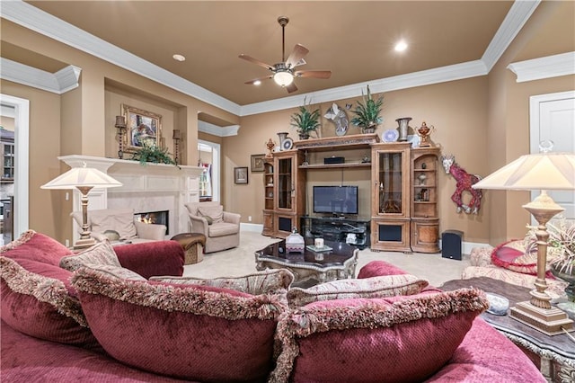 living area with baseboards, a ceiling fan, a premium fireplace, carpet, and crown molding