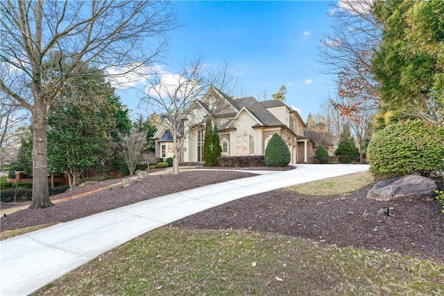 view of front of house featuring stone siding, concrete driveway, and stucco siding