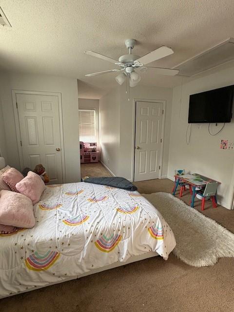 carpeted bedroom with ceiling fan and a textured ceiling