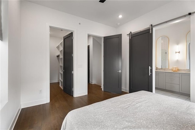 2347 Hosea L Williams Dr NE Unit 11, Atlanta, GA 30317 - bedroom featuring a barn door, wood finished floors, a spacious closet, and ensuite bathroom