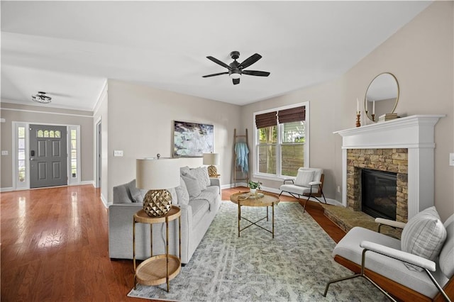 living room with a fireplace, ceiling fan, wood finished floors, and baseboards