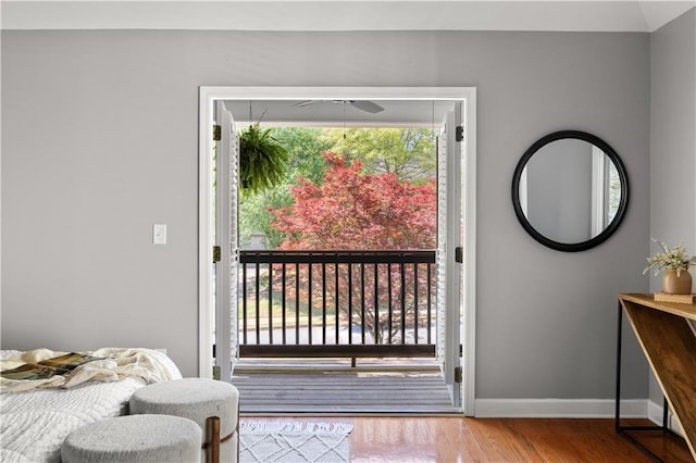 doorway to outside featuring wood finished floors, a ceiling fan, and baseboards