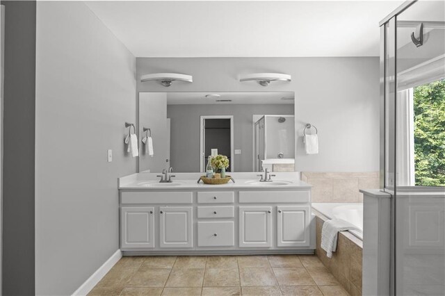 bathroom with a stall shower, a bath, tile patterned flooring, and a sink