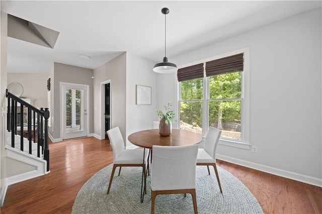 dining room with baseboards, stairway, and wood finished floors