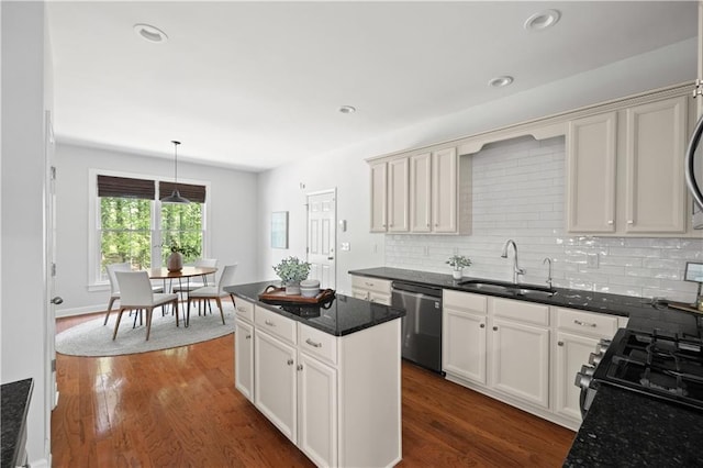 kitchen featuring a sink, decorative backsplash, pendant lighting, stainless steel dishwasher, and dark wood finished floors