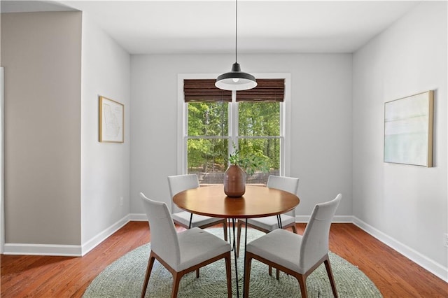 dining space featuring wood finished floors and baseboards