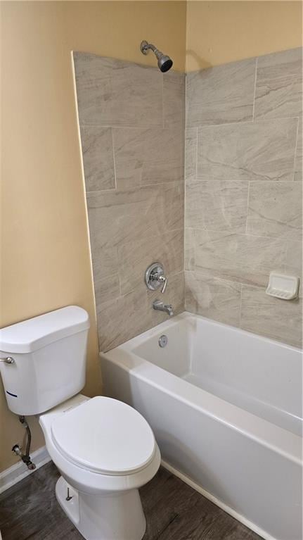 bathroom featuring toilet, tiled shower / bath, and wood-type flooring