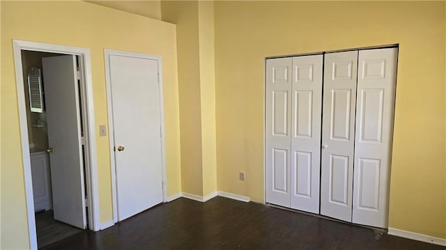 unfurnished bedroom featuring a closet and dark hardwood / wood-style flooring