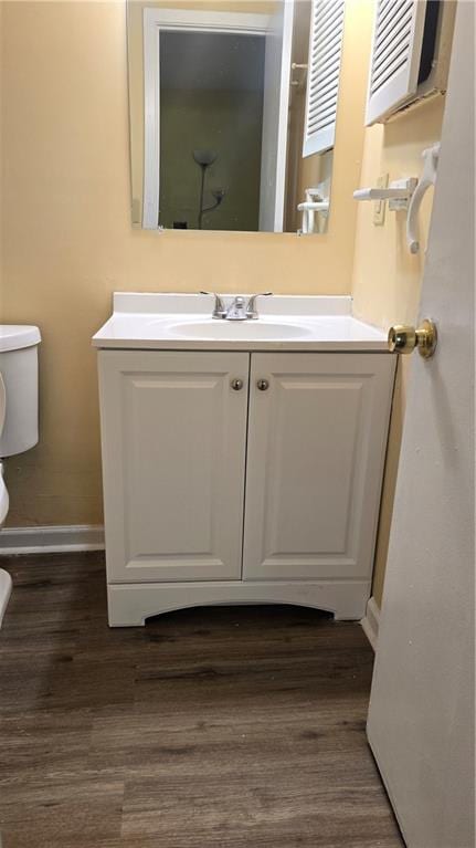 bathroom featuring vanity, hardwood / wood-style flooring, and toilet