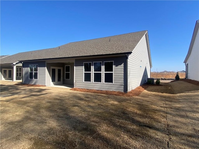 back of house with french doors and a shingled roof