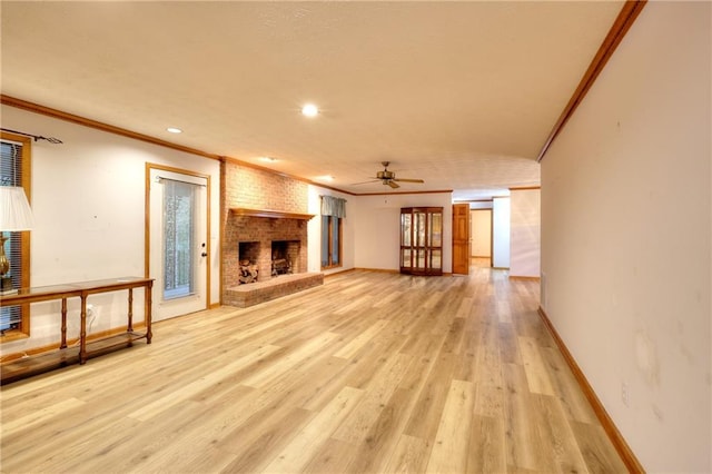 unfurnished living room featuring a brick fireplace, light hardwood / wood-style floors, ceiling fan, and crown molding