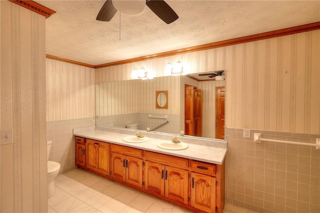 bathroom featuring tile walls, a textured ceiling, ornamental molding, vanity, and toilet