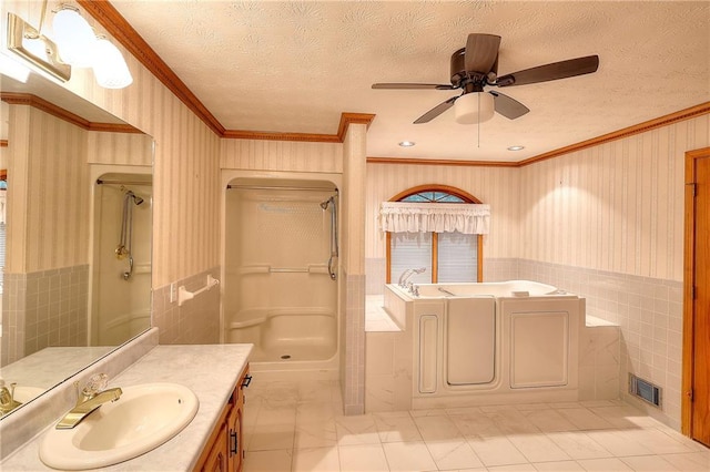 bathroom featuring tile walls, vanity, a textured ceiling, shower with separate bathtub, and ornamental molding