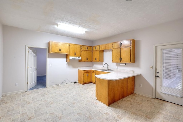 kitchen featuring sink, kitchen peninsula, and a textured ceiling