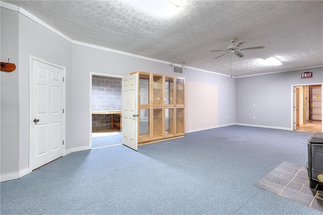 empty room featuring a textured ceiling, ceiling fan, and a wood stove