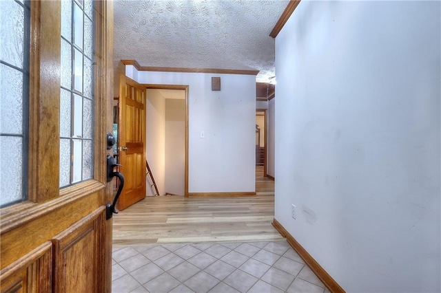 interior space with a textured ceiling, crown molding, and light hardwood / wood-style floors