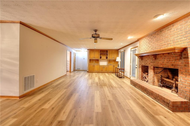 unfurnished living room featuring a brick fireplace, a textured ceiling, crown molding, and light hardwood / wood-style floors