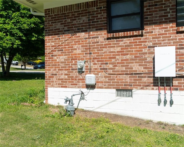 details with electric meter, brick siding, and gas meter