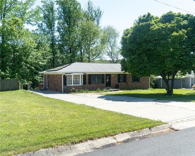 ranch-style home with fence, brick siding, and a front yard