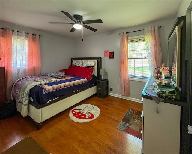 bedroom with ceiling fan, baseboards, and wood finished floors
