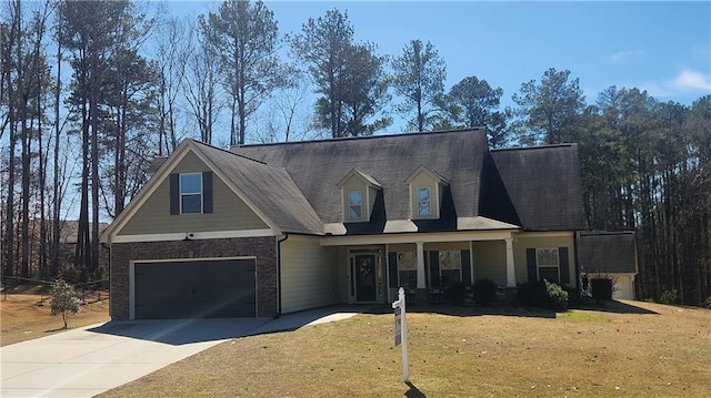 view of front facade with driveway, a garage, covered porch, a front lawn, and brick siding