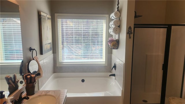 bathroom with a stall shower, a garden tub, and vanity