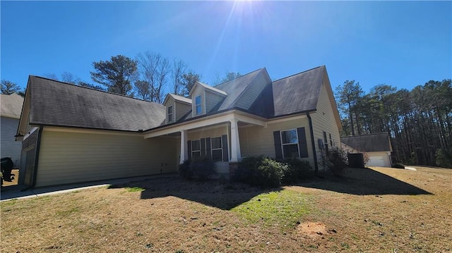 view of front of property with a garage, covered porch, and a front yard