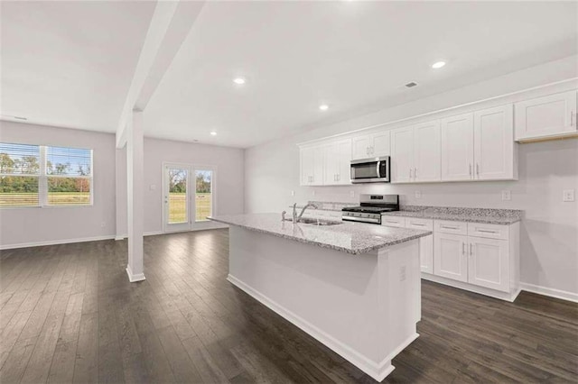 kitchen with stainless steel appliances, dark wood-type flooring, white cabinets, and a kitchen island with sink