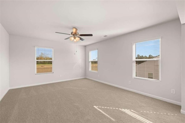 unfurnished room with carpet floors, a healthy amount of sunlight, and ceiling fan