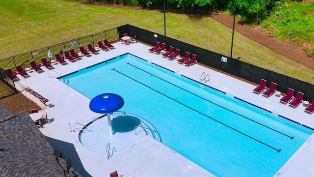 view of pool featuring a patio and a yard