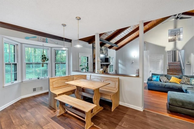 dining room featuring vaulted ceiling with beams and wood-type flooring